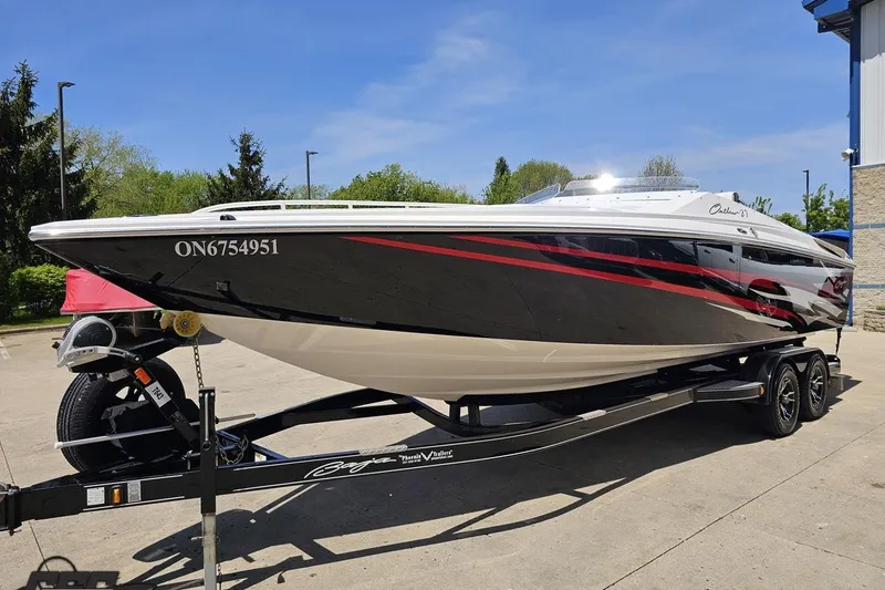 Slide: The Image of 2019 Baja 27 Outlaw speedboat on trailer, black and red design, parked outdoors. - 16