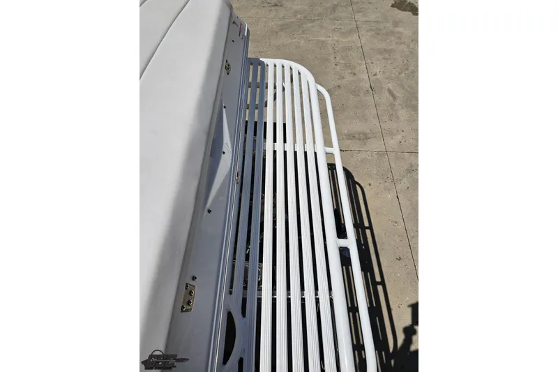 Slide: The Image of 2019 Baja 27 Outlaw boat deck with white railing, viewed from above. - 30