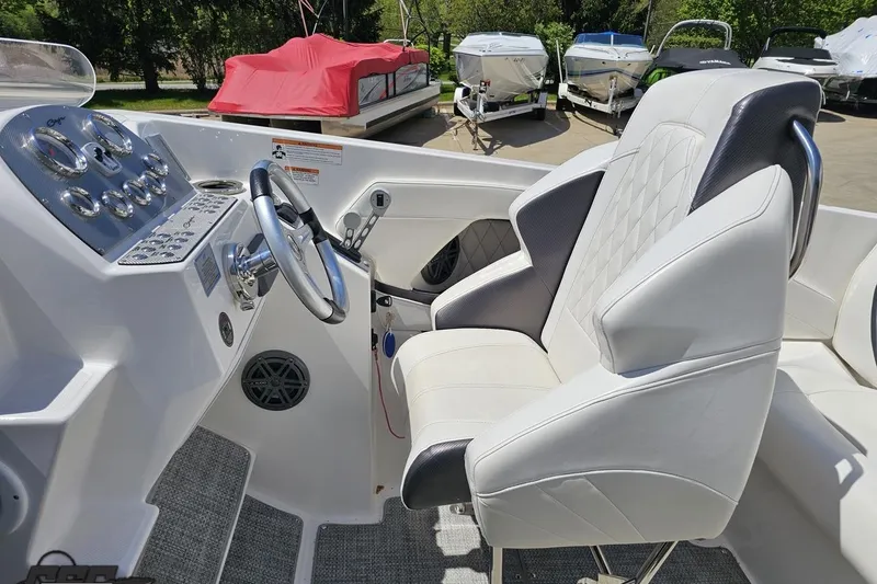 Slide: The Image of 2019 Baja 27 Outlaw boat interior with sleek white seating and modern dashboard controls. - 43