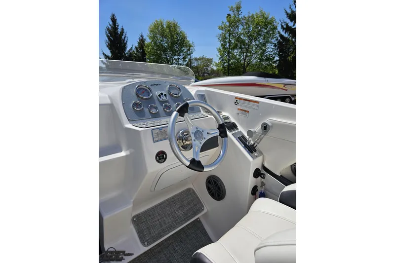 Slide: The Image of 2019 Baja 27 Outlaw boat cockpit with steering wheel and control panel, under clear blue sky. - 45