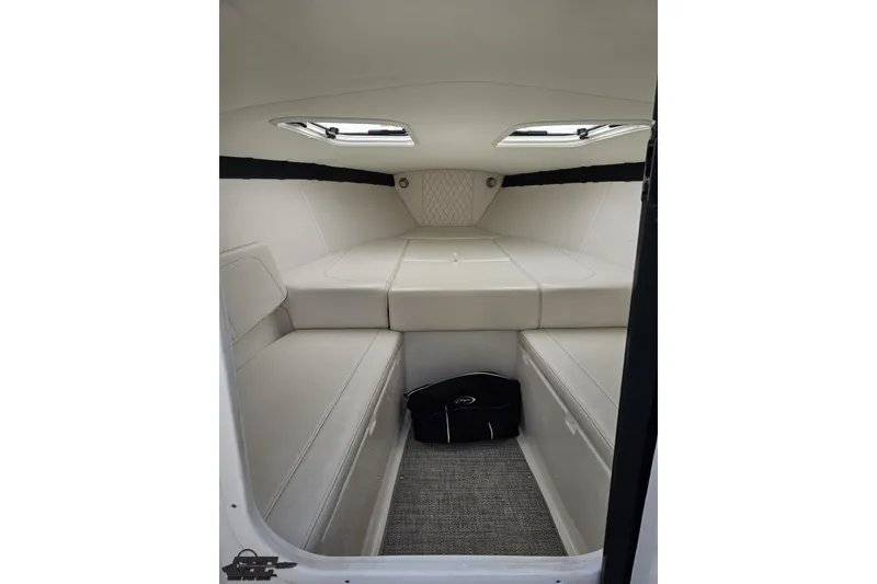 Slide: The Image of Interior cabin of 2019 Baja 27 Outlaw boat with white seating and storage. - 48