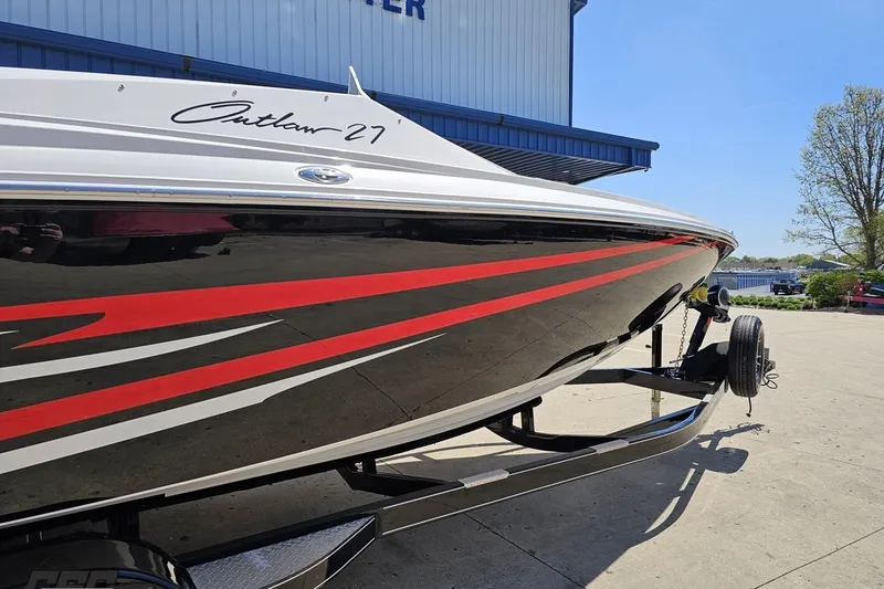 Slide: The Image of 2019 Baja 27 Outlaw boat with sleek red and black design on trailer. - 5