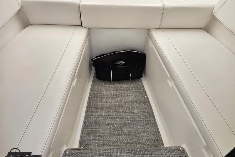 Slide: The Image of Interior of a 2019 Baja 27 Outlaw boat with white seating and a black bag. - 50