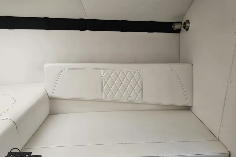 Slide: The Image of Interior of a 2019 Baja 27 Outlaw boat with white cushioned seating. - 52