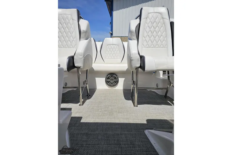 Slide: The Image of 2019 Baja 27 Outlaw boat interior with white diamond-stitched seats and speaker detail. - 57