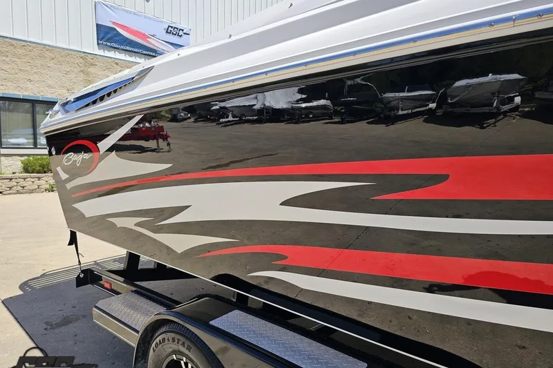 Slide: The Image of 2019 Baja 27 Outlaw boat with sleek red and white graphics on a trailer. - 7