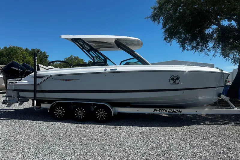 The Image of 2026 Monterey Elite 30 OB boat on trailer, sleek design under clear blue sky. - 1