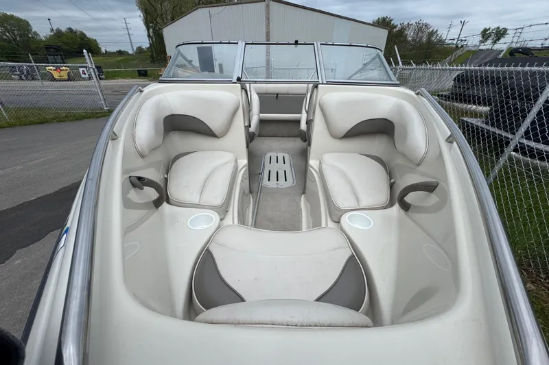 Slide: The Image of Interior view of a 2000 Crownline 180 BR boat with white seating and cup holders. - 1