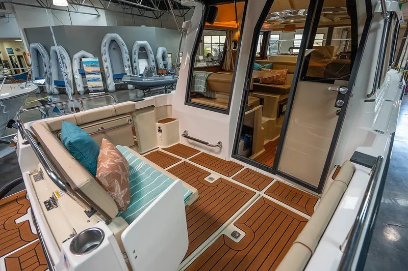 Slide: The Image of 2025 Ranger Tug R23 Luxury Edition boat interior with elegant seating and teak flooring. - 11