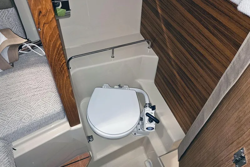 Slide: The Image of 2025 Ranger Tug R23 Luxury Edition interior with compact marine toilet and wood paneling. - 3