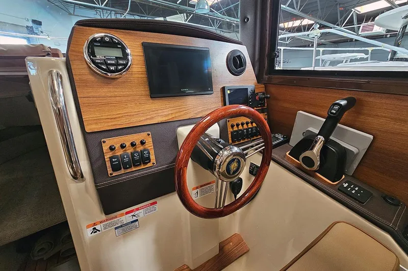 Slide: The Image of Helm of 2025 Ranger Tug R23 Luxury Edition with wood accents and modern controls. - 5