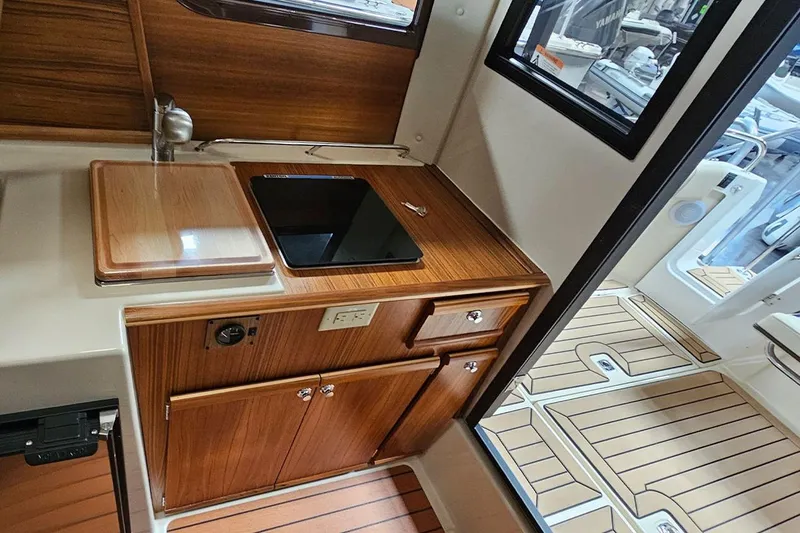 Slide: The Image of 2025 Ranger Tug R23 Luxury Edition interior with wood cabinetry and modern kitchen amenities. - 8
