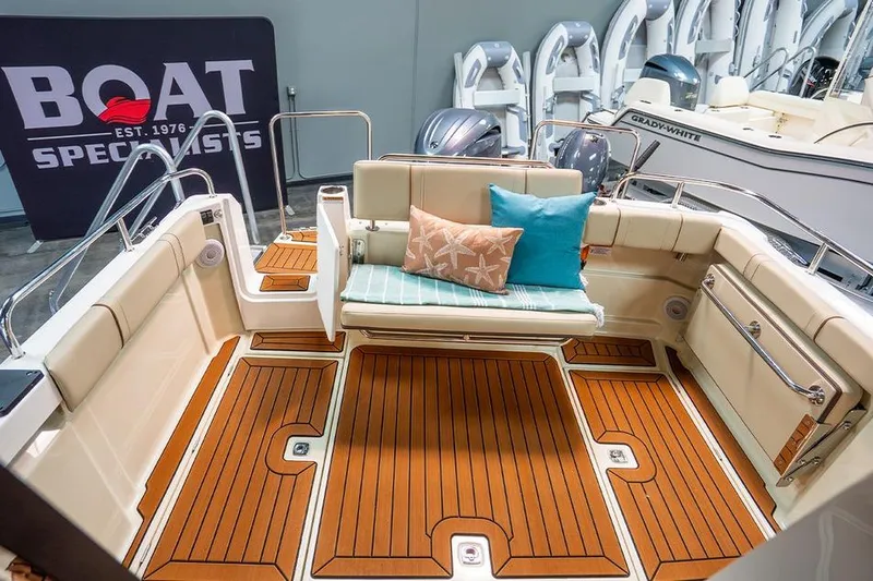 Slide: The Image of 2025 Ranger Tug R23 Luxury Edition boat interior with cushioned seating and teak flooring. - 9
