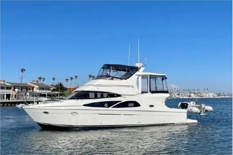 The Image of 2005 Carver 41 Cockpit Motor Yacht on calm water, clear sky background. - 1
