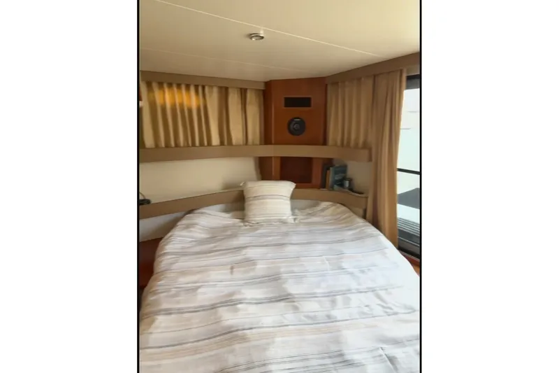Slide: The Image of Interior cabin of 2005 Carver 41 Cockpit Motor Yacht with cozy bed and curtains. - 9