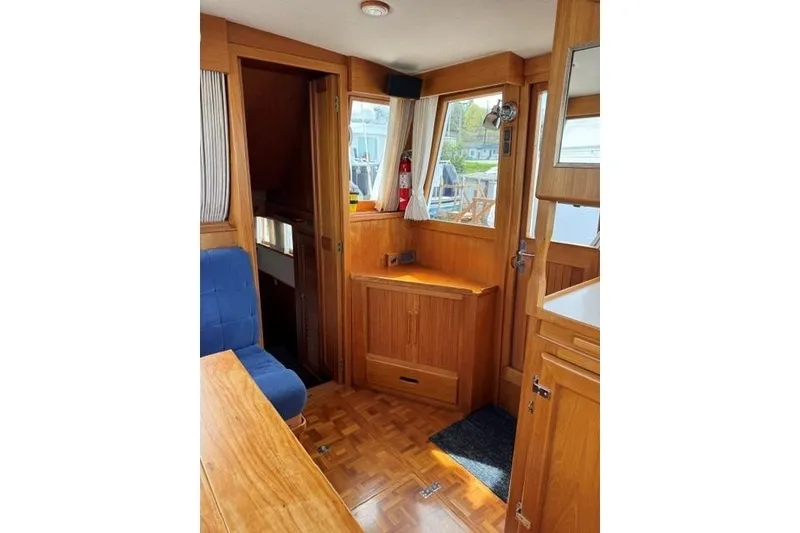 Slide: The Image of Interior of 2000 Grand Banks 36 Classic yacht with wooden furnishings and blue seating. - 10
