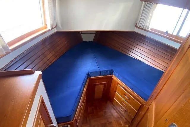 Slide: The Image of Cozy cabin interior of 2000 Grand Banks 36 Classic with blue bedding and wooden finish. - 13