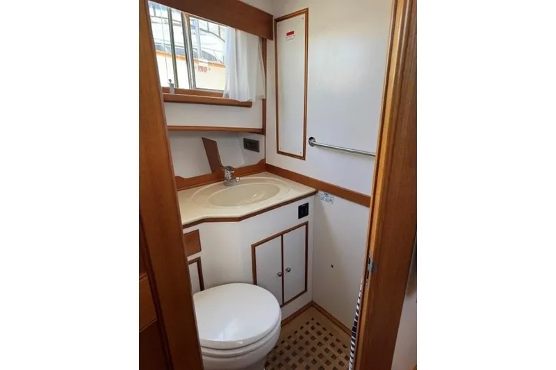 Slide: The Image of 2000 Grand Banks 36 Classic yacht bathroom with sink, toilet, and wooden accents. - 15