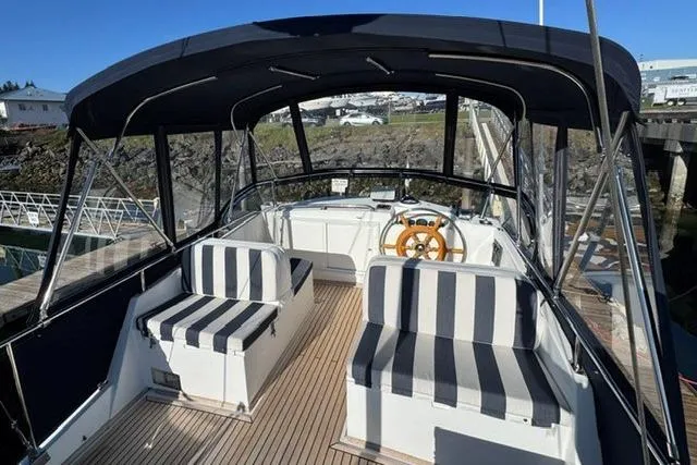 Slide: The Image of 2000 Grand Banks 36 Classic yacht with striped seating and wooden steering wheel. - 16