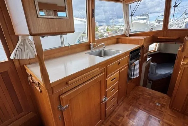 Slide: The Image of Interior of a 2000 Grand Banks 36 Classic yacht with wooden cabinetry and a compact kitchen. - 7