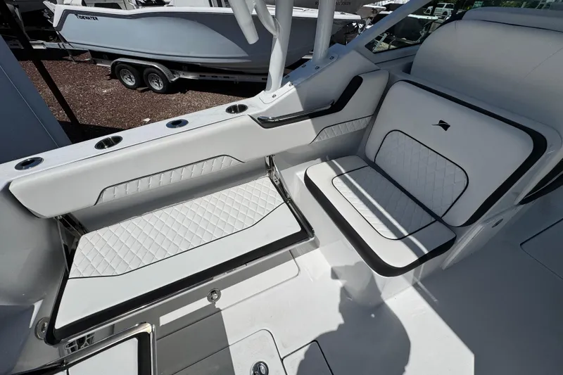 Slide: The Image of 2026 Stingray 259 DC boat interior with white quilted seating and cup holders. - 17
