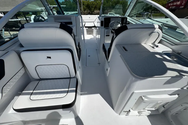 Slide: The Image of 2026 Stingray 259 DC boat interior with white seating and modern dashboard. - 18