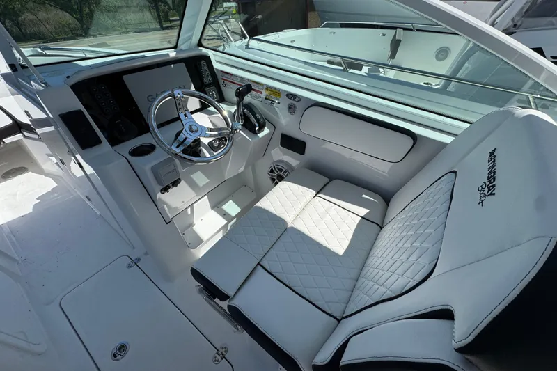 Slide: The Image of 2026 Stingray 259 DC boat interior with modern helm, steering wheel, and quilted seating. - 19