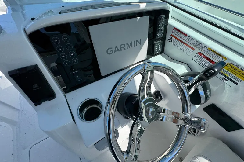 Slide: The Image of 2026 Stingray 259 DC boat dashboard with Garmin navigation system and chrome steering wheel. - 20
