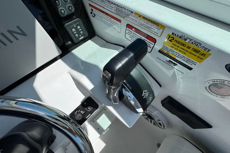 Slide: The Image of 2026 Stingray 259 DC boat cockpit with controls and capacity warning labels. - 22