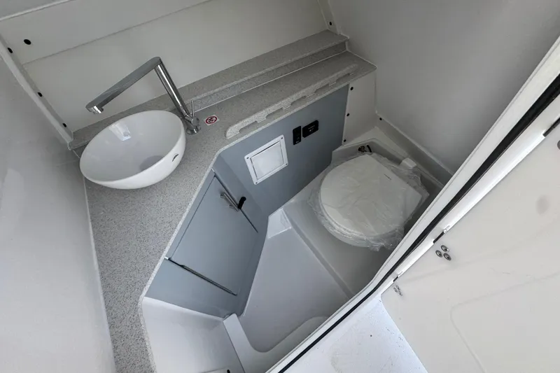 Slide: The Image of 2026 Stingray 259 DC boat bathroom with modern sink and toilet setup. - 26