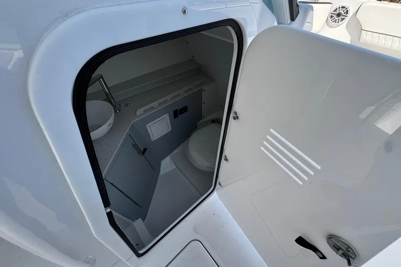 Slide: The Image of Interior view of 2026 Stingray 259 DC boat's compact bathroom with sink and toilet. - 27