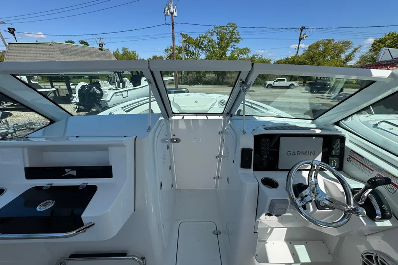 Slide: The Image of 2026 Stingray 259 DC boat cockpit with Garmin navigation system and sleek steering wheel. - 28
