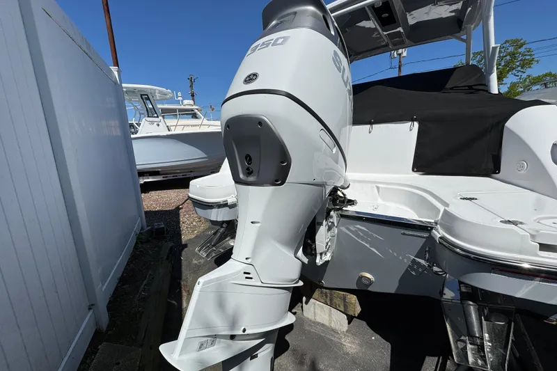 Slide: The Image of 2026 Stingray 259 DC boat with powerful outboard motor in a marina setting. - 3