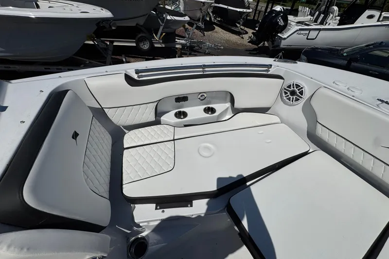 Slide: The Image of 2026 Stingray 259 DC boat interior with white cushioned seating and cup holders. - 30
