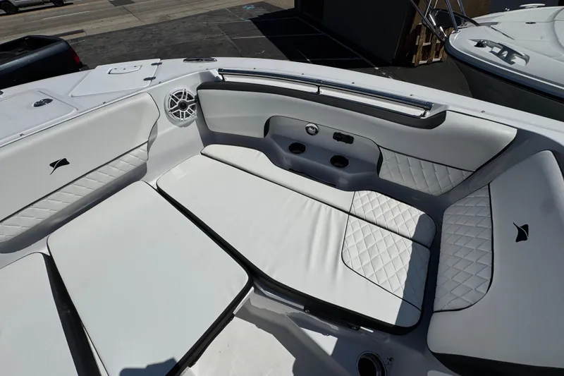 Slide: The Image of 2026 Stingray 259 DC boat interior with white cushioned seating and speaker system. - 31