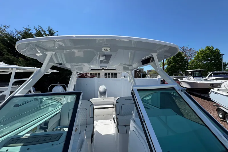 Slide: The Image of 2026 Stingray 259 DC boat with sleek design and spacious seating under a clear blue sky. - 37