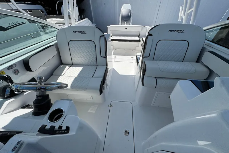 Slide: The Image of 2026 Stingray 259 DC boat interior with dual seating and modern steering console. - 38