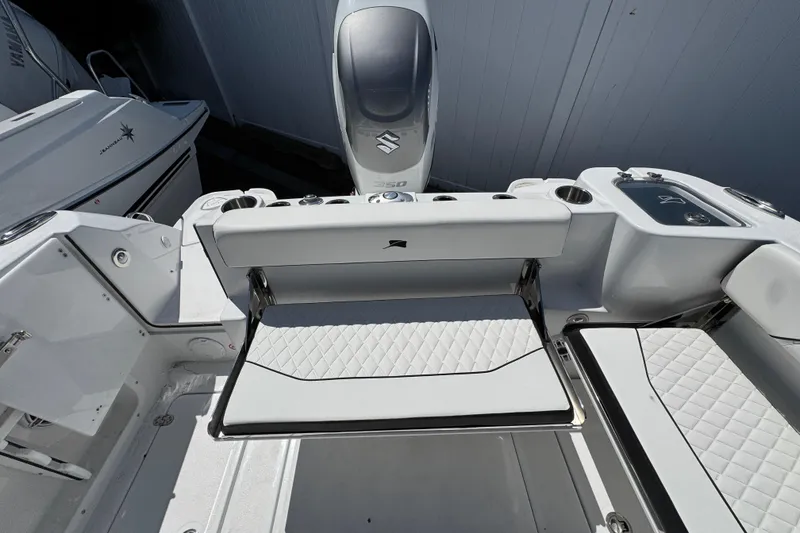 Slide: The Image of 2026 Stingray 259 DC boat interior with white seating and Suzuki engine. - 40