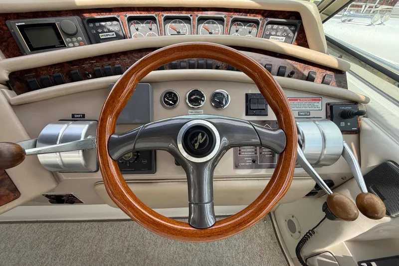 Slide: The Image of 1998 Sea Ray 500 Sundancer helm with wooden steering wheel and control panel. - 25