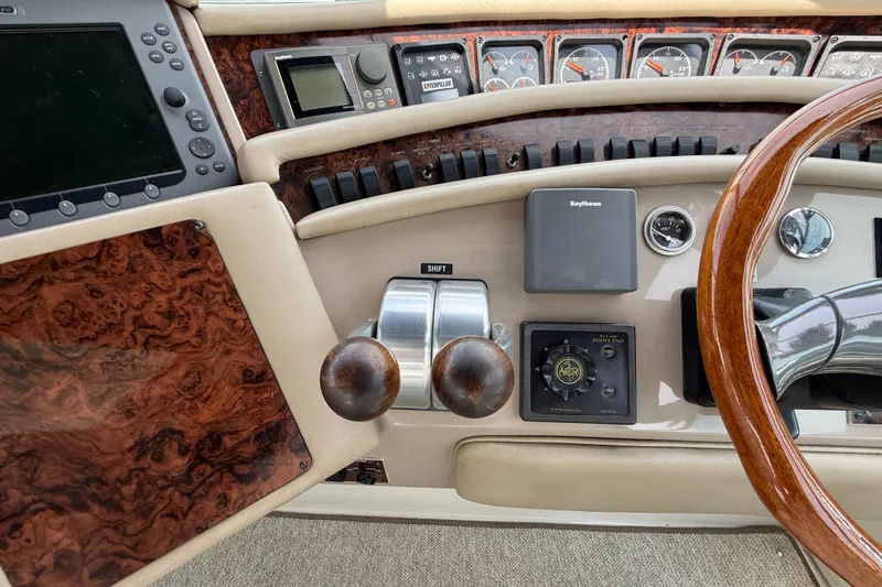 Slide: The Image of Control panel of a 1998 Sea Ray 500 Sundancer yacht with wood accents and navigation instruments. - 27