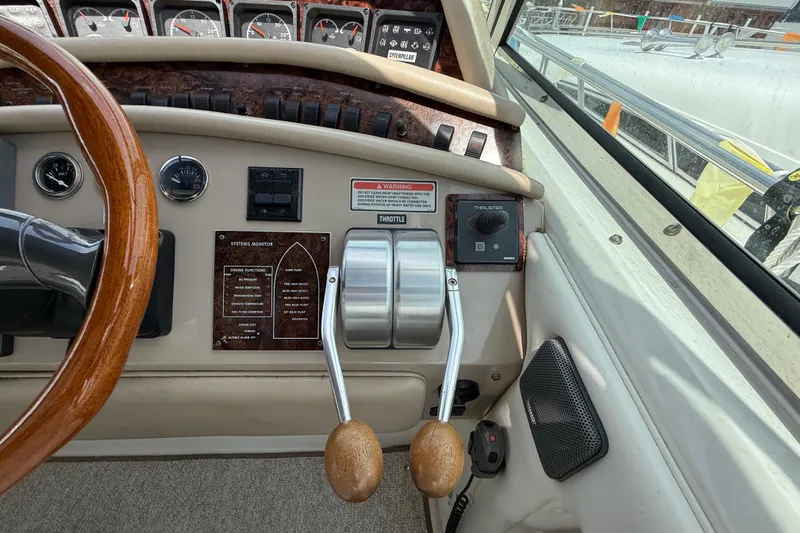 Slide: The Image of Control panel of a 1998 Sea Ray 500 Sundancer yacht with steering wheel and throttle levers. - 28