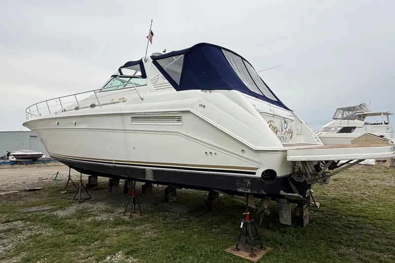 Slide: The Image of 1998 Sea Ray 500 Sundancer yacht on stands, featuring a sleek white hull and blue canopy. - 3