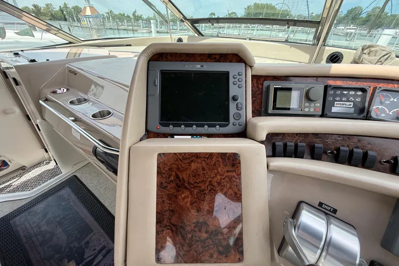 Slide: The Image of 1998 Sea Ray 500 Sundancer helm with navigation controls and wood paneling. - 35