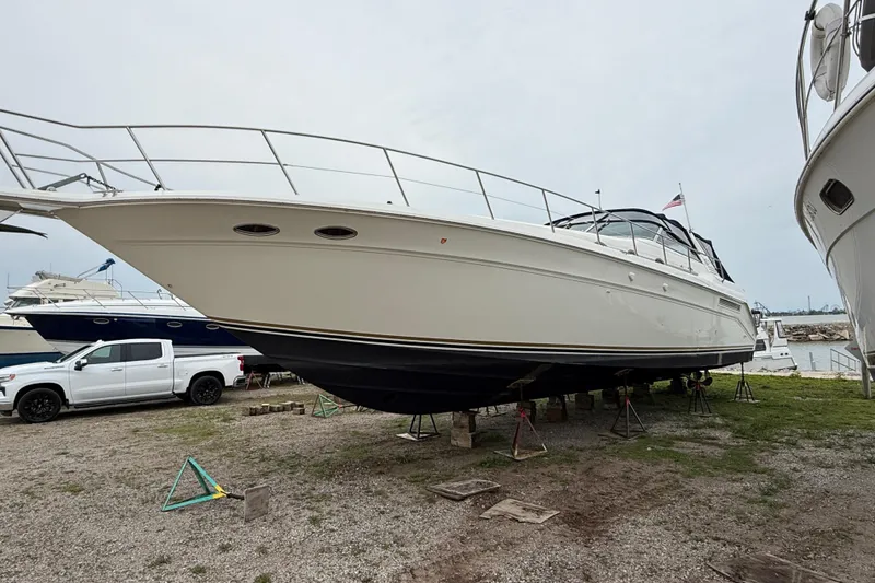 Slide: The Image of 1998 Sea Ray 500 Sundancer yacht on dry dock, side view with overcast sky. - 4