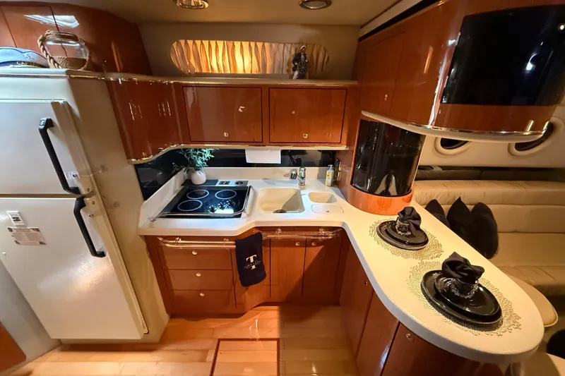 Slide: The Image of Luxurious 1998 Sea Ray 500 Sundancer yacht kitchen with modern amenities and elegant wood cabinetry. - 49