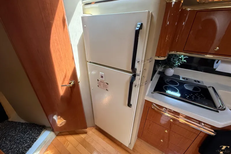 Slide: The Image of Kitchen area of 1998 Sea Ray 500 Sundancer with fridge and stovetop. - 62
