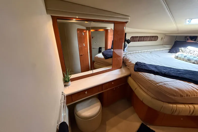 Slide: The Image of Luxurious 1998 Sea Ray 500 Sundancer cabin with bed, mirror, and vanity area. - 66