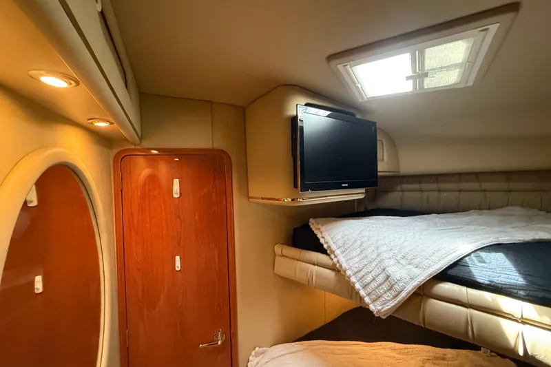 Slide: The Image of 1998 Sea Ray 500 Sundancer cabin interior with bed, TV, and wooden door. - 75