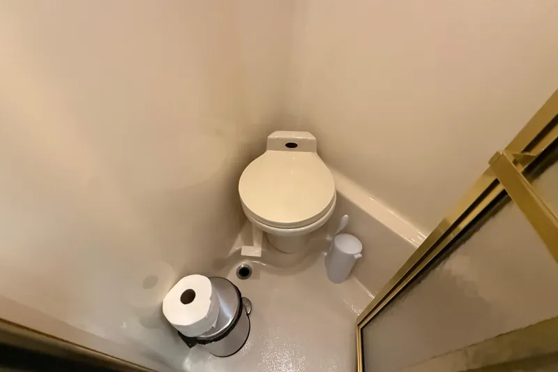 Slide: The Image of Compact bathroom on 1998 Sea Ray 500 Sundancer yacht, featuring toilet and shower. - 80