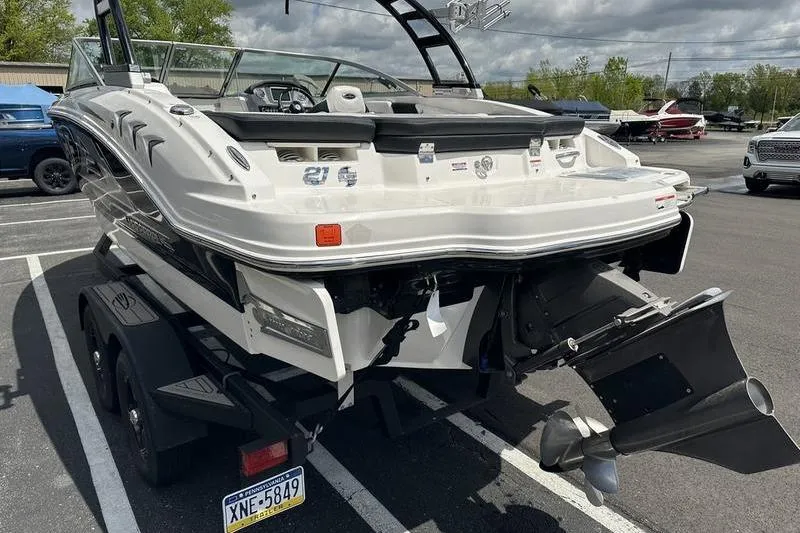 Slide: The Image of 2021 Chaparral 21 Surf boat on trailer, rear view, parked in lot. - 15